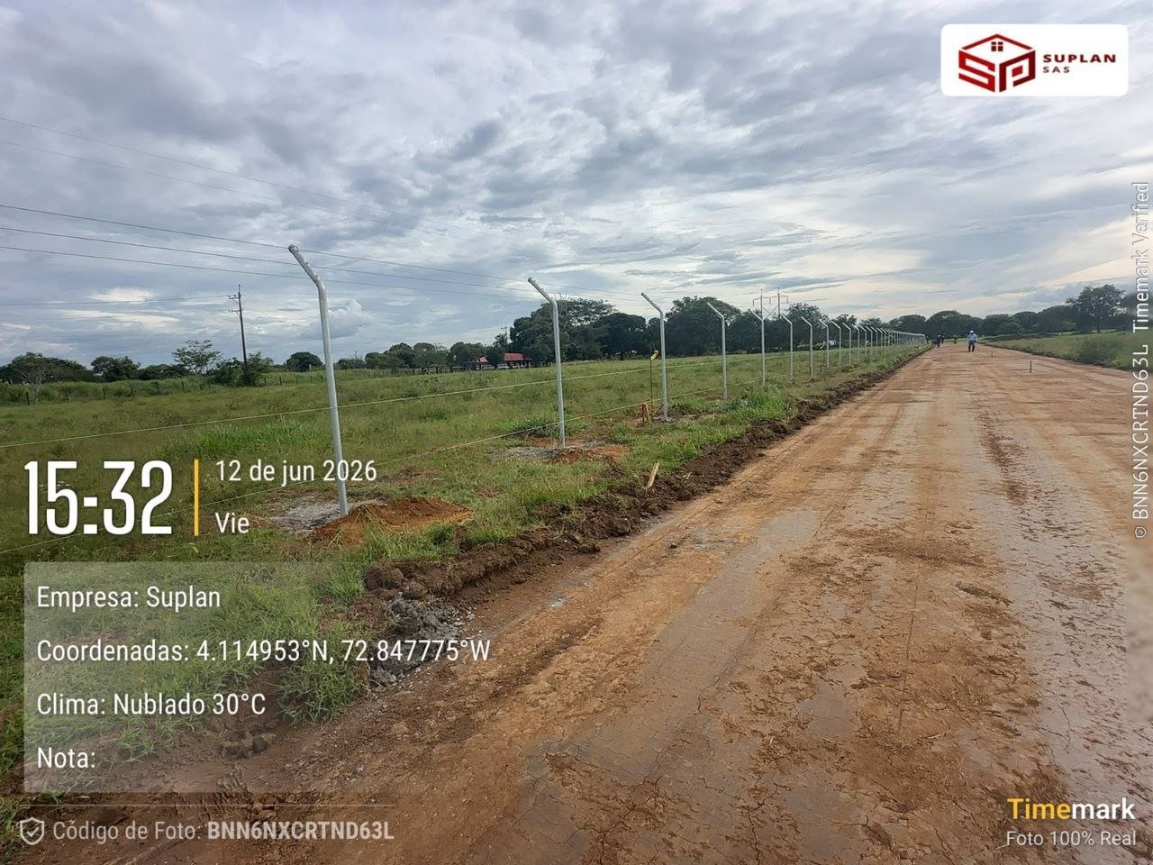 Dirt road through agricultural land with green fields and street lights, timestamped June 12, 2026 at 15:32, location coordinates displayed